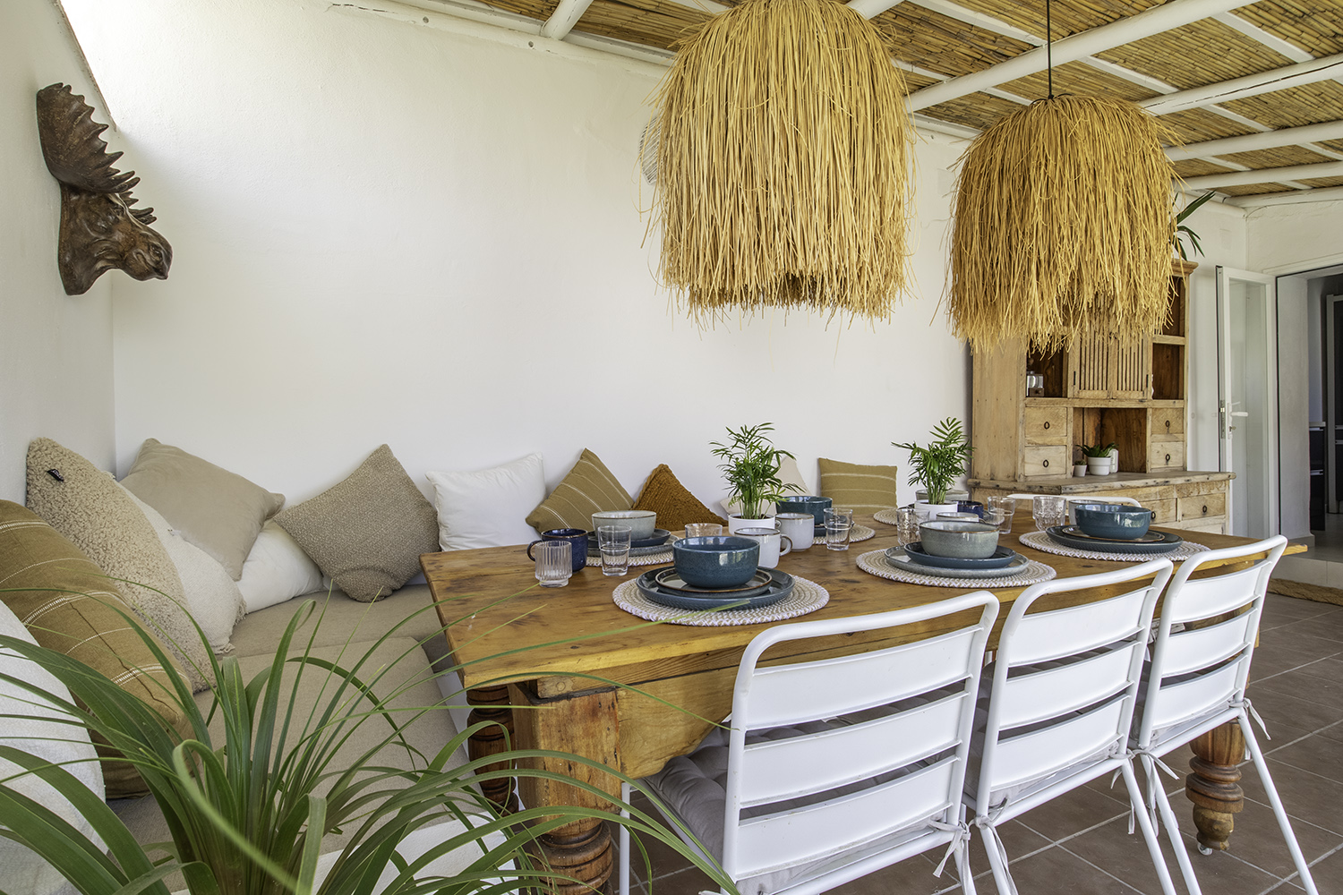 Breakfast on the terrace at Casa Jardín — long table under woven pendant lamps.