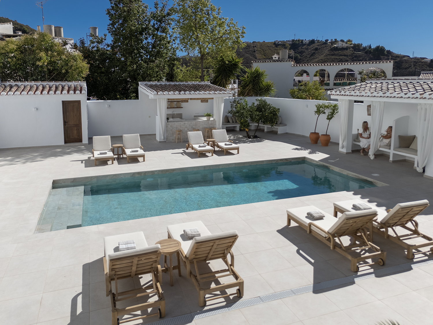 The salt-water pool at Casa Jardín, framed by jasmine and bougainvillea, the Sierra de Almijara rising behind.